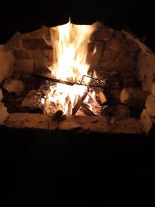 a fire in a brick fireplace at night at Tent Camping in Sarajevo