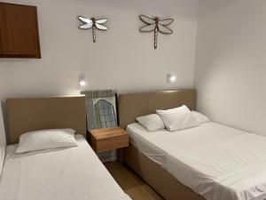 a room with two beds and a clock on the wall at Apartments Lungo Mare in Sveti Stefan