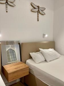 a bedroom with a bed with a mirror on it at Apartments Lungo Mare in Sveti Stefan