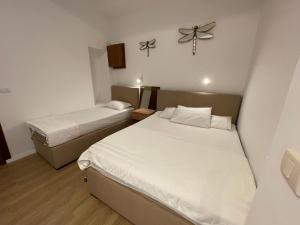 a room with two beds and a clock on the wall at Apartments Lungo Mare in Sveti Stefan