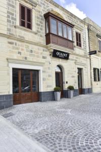 a building with a sign on the front of it at Quaint Boutique Hotel Xewkija in Xewkija