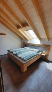 Bett in einem Zimmer mit Holzdecke in der Unterkunft Ferienwohnungen Am Kapellenberg Losheim am See in Losheim