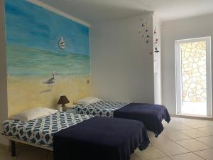 two beds in a room with a painting on the wall at Lagos Marina Guest House in Lagos