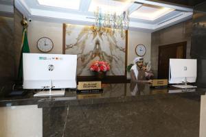 una hall con due monitor e orologi sul muro di Weekend Hotel Sari a Gedda