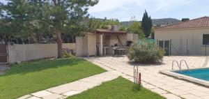 un patio trasero con piscina y una casa en Villa Style Provencal en Gignac-la-Nerthe