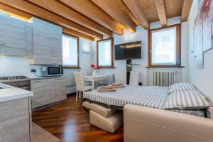 eine Küche und ein Wohnzimmer mit einem Bett in einem Zimmer in der Unterkunft New Ride Palmanova Apartment in Palmanova