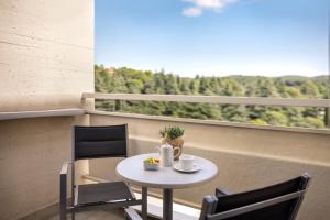 a small table and chairs on a balcony with a view at Valamar Diamant Hotel in Poreč