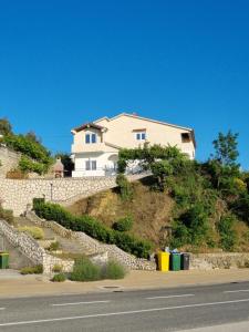 uma casa sentada em cima de uma parede de pedra em Mariva Apartments em Lopar