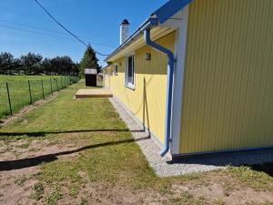 a yellow building with a fence next to it at Paju Majutus! in Ohtja