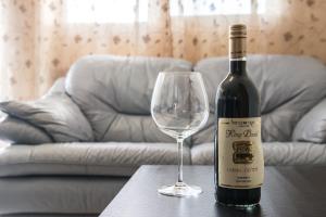 a bottle of wine and a glass on a table at Yaakov's Apartment in Migdal Ha‘Emeq