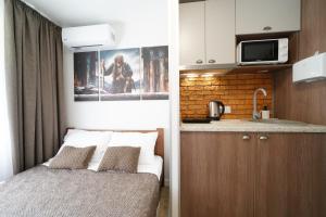 Il comprend une petite chambre avec un lit et une cuisine. dans l'établissement MYFREEDOM Апартаменти Інститут Хірургії Шалімова, à Kiev
