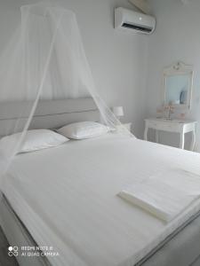a white bed with white sheets and pillows at Ortensia in Oziás