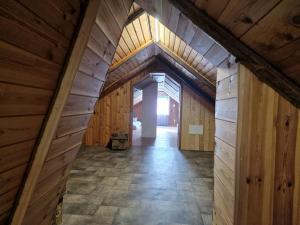 an inside view of a barn with wooden walls and a hallway at Paju Majutus! in Ohtja