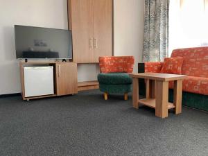 sala de estar con sofá, mesa y TV en Motel Gilau en Gilău