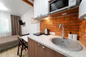a kitchen with a sink and a brick wall at Апартаменти MYFREEDOM поруч інститут Шалімова in Kyiv +17 photos