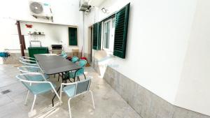 un patio con tavolo e sedie in un edificio di Villa Golfinho by Sunny Deluxe ad Albufeira