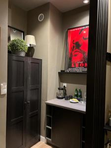 a room with a table and a cabinet and a painting at Apartamenty Nova 22 in Toruń