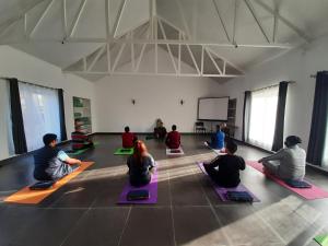 a group of people sitting in a yoga class at Neer Ganga Resorts in Rishīkesh