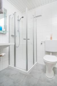 a white bathroom with a shower and a toilet at Gästehaus Wulz-Lesjak in Egg am Faaker See