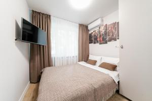 a bedroom with a bed and a flat screen tv at Апартаменти MYFREEDOM поруч інститут Шалімова in Kyiv