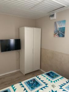 Un dormitorio con una cama y un armario. en TópART Apartman B Little House en Balatonfenyves