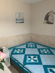 um quarto com uma cama com uma colcha azul e branca em TópART Apartman B Little House em Balatonfenyves