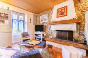 ein Wohnzimmer mit einem Kamin und einem TV in der Unterkunft Une maison de charme avec jardin sur l’île de Noirmoutier in LʼÉpine