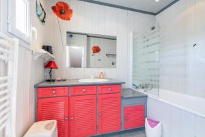 a bathroom with red cabinets and a sink at Au cœur de l'île, maison pour 6 adultes, 1 enfant in LʼÉpine +25 photos