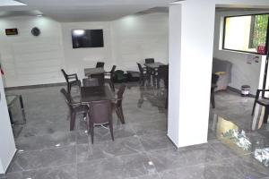 a dining room with tables and chairs and a tv at Gurya in Kobuleti
