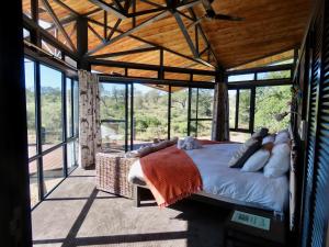 a bedroom with a bed in a room with windows at Greenfire Game Lodge in Balule Game Reserve