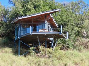 une cabane dans les arbres au milieu d'un champ dans l'établissement Greenfire Game Lodge, à Réserve de Balule