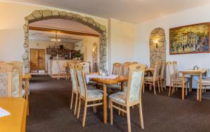 een eetkamer met tafels en stoelen en een stenen muur bij Hotel U Nádraží in Tepla