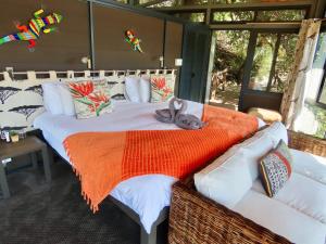 a bed with a stuffed rabbit laying on it at Greenfire Game Lodge in Balule Game Reserve