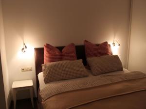 1 dormitorio con 1 cama con almohadas rojas y blancas en Ferienhaus Lena, en Seebach