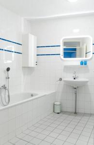 ein weißes Badezimmer mit einem Waschbecken, einer Badewanne und einem WC in der Unterkunft Residence Juliana 14 Julianadorp aan zee in Julianadorp
