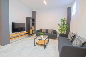 sala de estar con 2 sofás y TV en El Patio del Sol, apartamentos Living Sur, en Sanlúcar de Barrameda