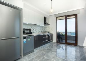 a kitchen with stainless steel appliances and a large window at Gazioğlu Residence in Trabzon
