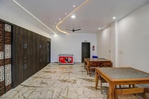 een kamer met houten tafels en een tv. bij Hotel Four Petals in Bhopal