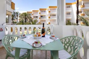 a table with two chairs and a bottle of wine at Holiday Beach in Denia