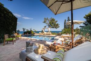 een achtertuin met een zwembad en een parasol bij Extraordinary view with a Cobalt pool on the Tuscany coast in Porto Ercole