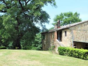 Le PiazzeにあるLa Fontaiolaの木を背景にした古い石造りの家