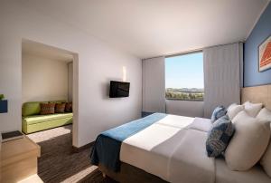 a hotel room with a large bed and a window at Valamar Diamant Hotel in Poreč
