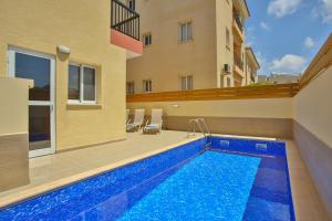 a swimming pool in front of a building at Star House in Paphos City