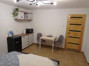 una pequeña cocina con mesa y sillas en una habitación en Freya´s room, en Česká Kamenice