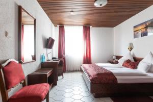 a hotel room with a bed and a desk and window at Hotel Weinhaus Wiedemann in Ginsheim-Gustavsburg