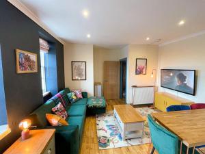 a living room with a green couch and a table at Lively & Energetic 2BR on The Royal Mile in Edinburgh