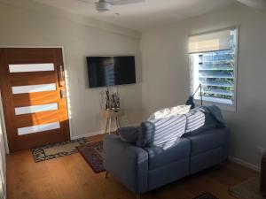 a living room with a couch and a flat screen tv at Self Contained Apartment, Queen bed, Own deck & great views in Coolum Beach