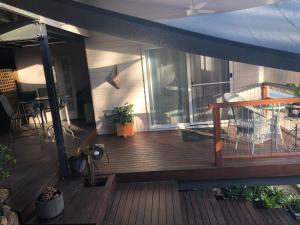 eine große Holzterrasse mit einem großen Fenster auf einem Haus in der Unterkunft Self Contained Apartment, Queen bed, Own deck & great views in Coolum Beach