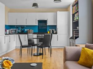 a kitchen with white cabinets and a table and chairs at Pass the Keys Perfect 1-bed base in Canterbury with Parking in Canterbury