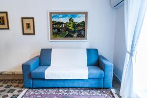une chaise bleue dans une pièce ornée d'une peinture murale dans l'établissement Casa Nà Za Maria, à Modica